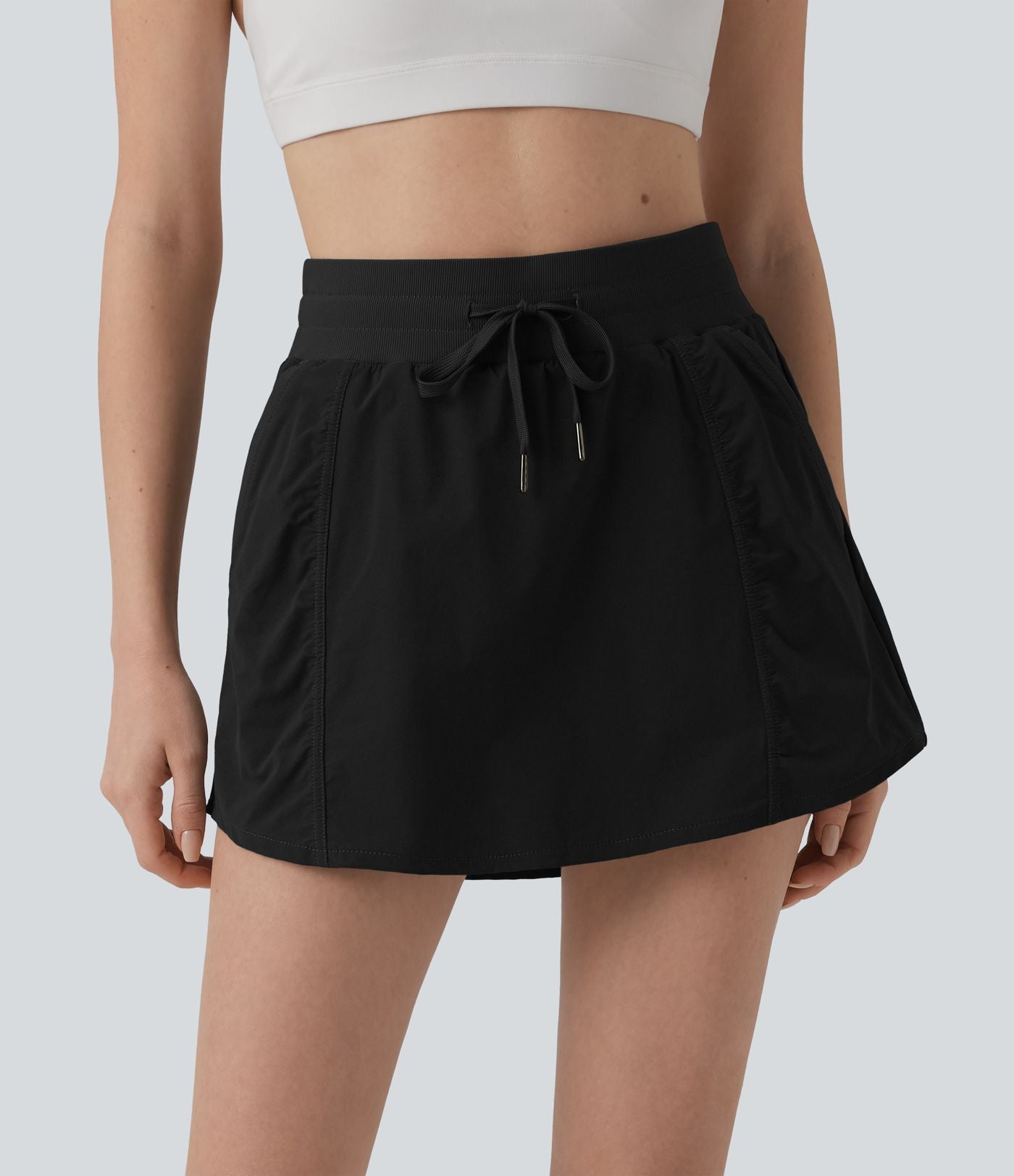 Jupe de sport mini 2-en-1 taille haute coupe trapèze avec cordon de serrage et poches