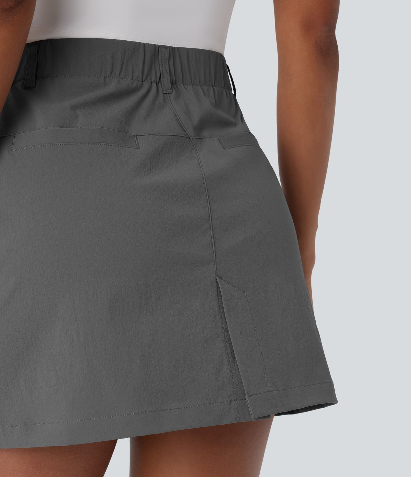 Jupe courte de golf ligne A taille haute avec boutons, zip, poches latérales et fente