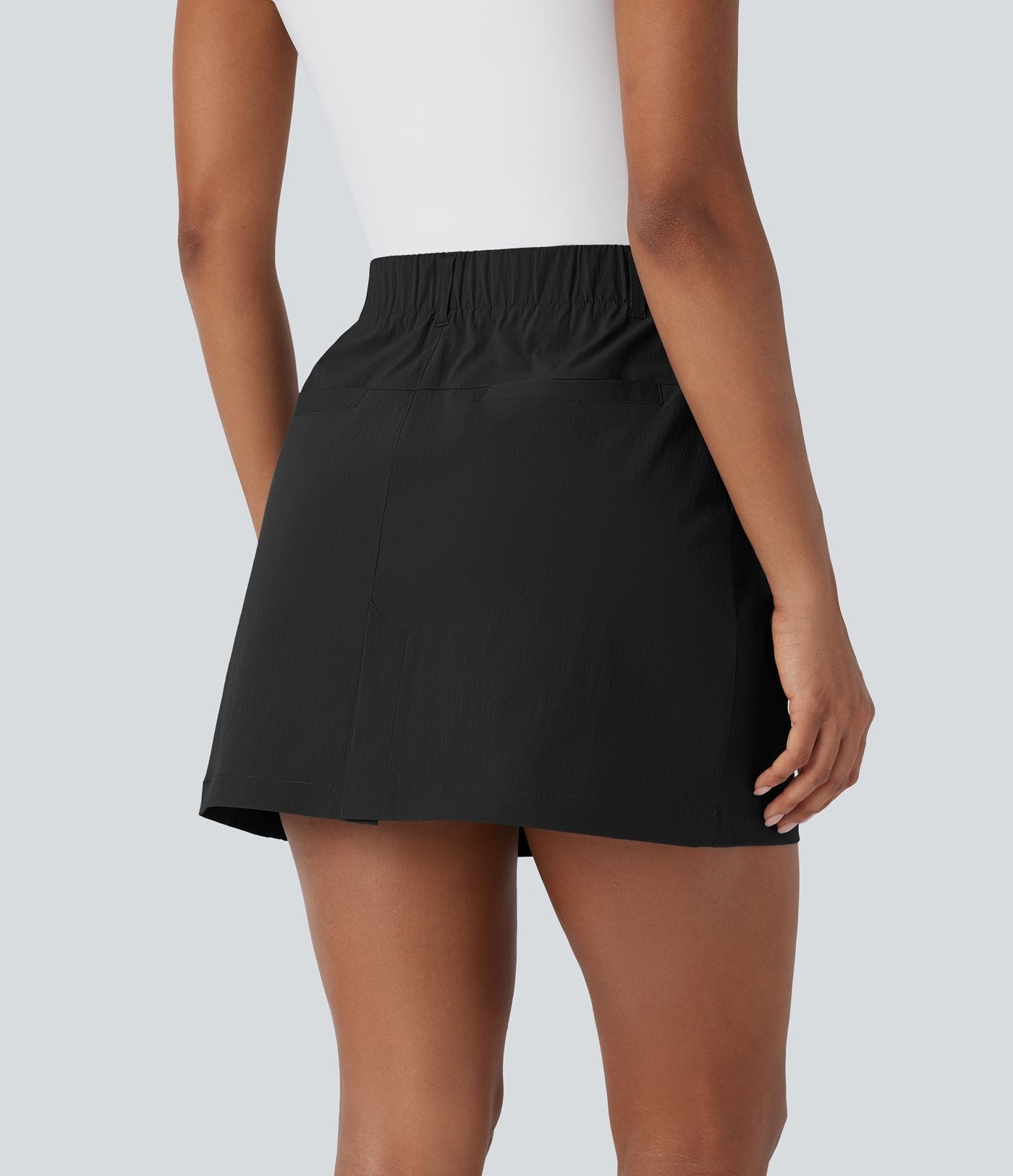 Jupe courte de golf ligne A taille haute avec boutons, zip, poches latérales et fente