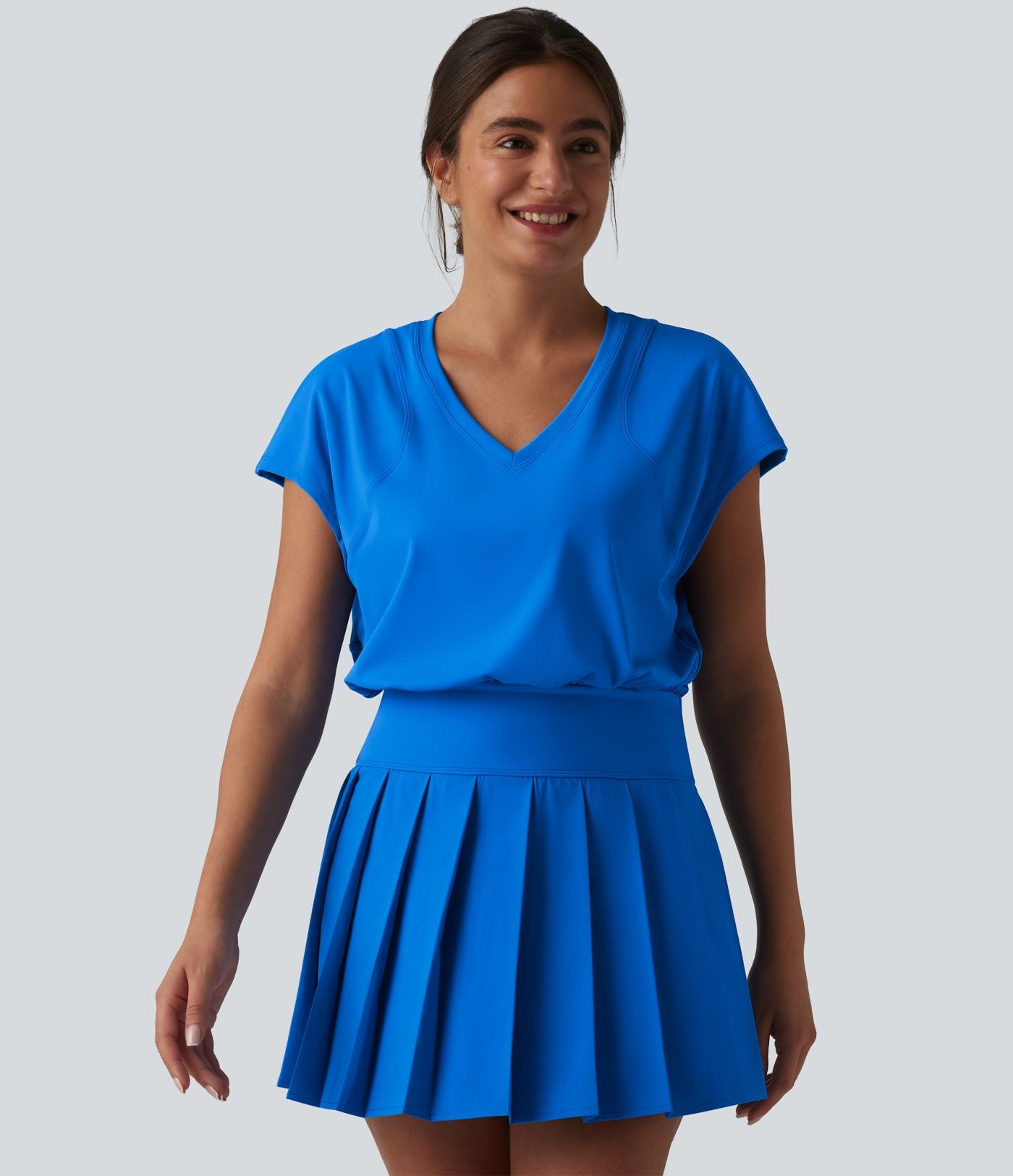 Robe sport de tennis mini 2-en-1 à col V, manches courtes et ourlet plissé avec fermeture éclair invisible et poches