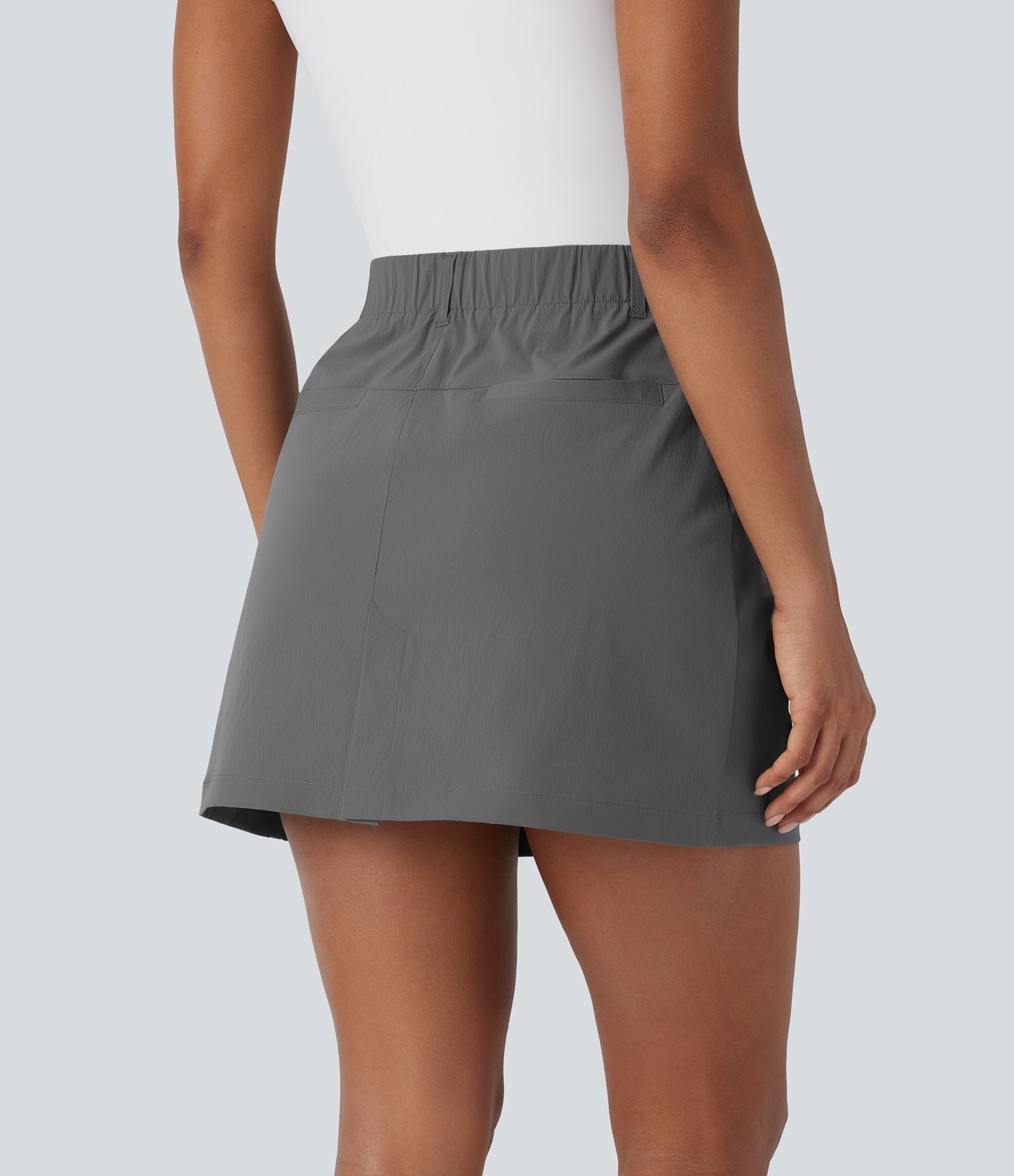 Jupe courte de golf ligne A taille haute avec boutons, zip, poches latérales et fente