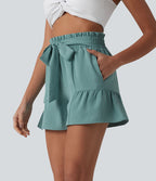Short resort large aspect lin taille haute froncée avec nœud frontal, ourlet volanté et poches